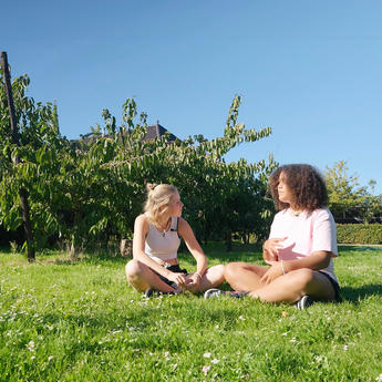 two young ladies discussing on the grass from Between Teenagers series