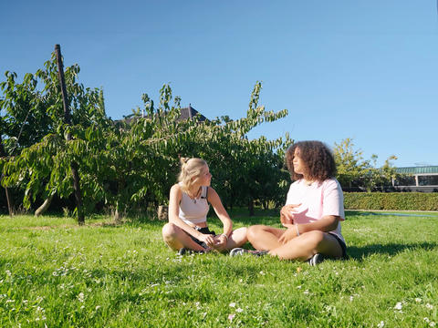 two young ladies discussing on the grass from Between Teenagers series