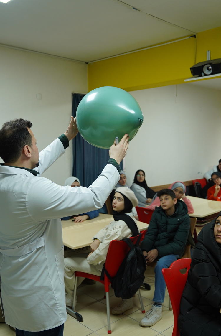 Picture of a teacher holding a balloon in front of students